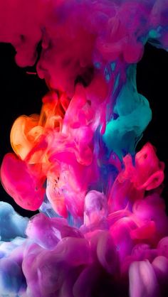 colorful ink is mixed in with each other to create an abstract color effect on the black background