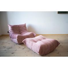 two pink chairs sitting on top of a wooden floor