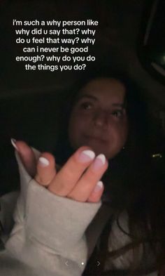 a woman holding her hand up in the back seat of a car with a message written on it