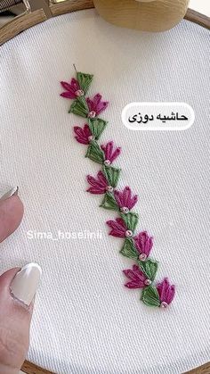 someone is stitching flowers on a piece of fabric