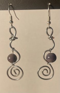 the earrings are made with silver wire and glass bead, which is hanging from hooks