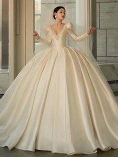 a woman in a wedding dress is posing for the camera with her arms out and hands on her hips