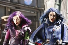 two women with purple hair are walking down the street and one has her mouth open