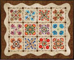 a quilt with many different designs and colors on the front, along with brown border