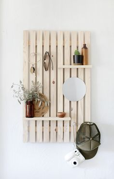 a wooden shelf with various items on it and a hat hanging from the wall next to it