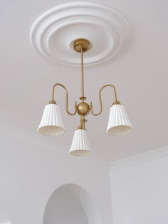 three lights are hanging from the ceiling in a room with white walls and flooring