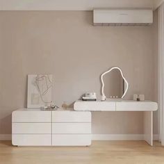 a white dresser sitting in front of a mirror on top of a wooden floor next to a wall mounted air conditioner