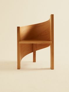 a wooden chair sitting on top of a white floor next to a brown wall with a shadow coming from it