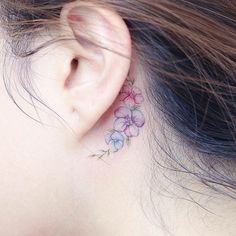 a close up of a person's ear with flowers on it