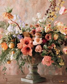 a vase filled with lots of flowers on top of a table