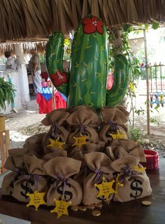 a large cactus sitting on top of a pile of burl bags filled with money