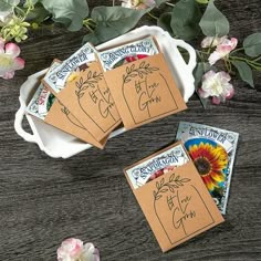 four seed packets are sitting on a table next to flowers