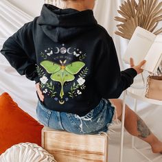 For all my Nature Lovers and Fairies we came out with this whimsical and magical Green Luna Moth Hoodie! Prepare to be complimented! You are Magic! This Mystical Celestial Aesthetic Moths Botanical Sweatshirt looks gorgeous! One-of-a kind, it features Green Luna Moth in a setting of plants and flower, moon phases, sparkling stars and inspirational saying. Hoodie has designs both, in front and on the back. This unisex heavy blend hooded sweatshirt is relaxation itself. Made with a thick blend of cotton and polyester, it feels plush, soft and warm, a perfect choice for any cold day.  Our Fairy core Pullover is a pretty gift for yourself and for all Ladies and Nature Lovers out there. This wonderful print makes fall in love with this sweater more and more. Stay beautiful! Dress like it's your Aesthetic Moth, Cottagecore Jacket, Comet Moth, Moth Shirt, Fairycore Aesthetic, Animal Sweatshirt, Luna Moth, Gildan Sweatshirts, Nature Inspired Design