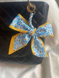 a black purse with a blue and yellow bow on it