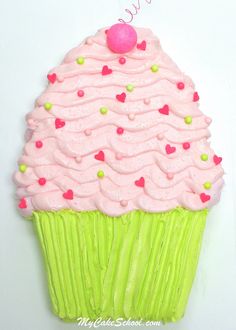 a cupcake decorated with pink icing and sprinkles on a white surface