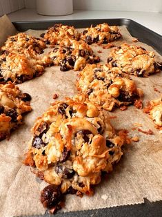 an uncooked batch of cookies sitting on top of a baking sheet with raisins