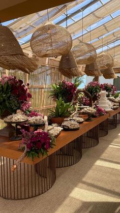 a long table topped with lots of flowers and desserts on top of wooden tables