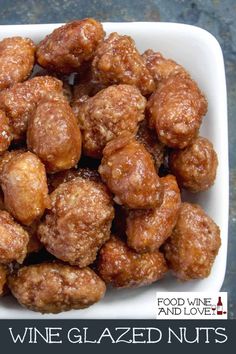 a white bowl filled with glazed nuts on top of a table