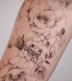 a close up of a tattoo with flowers on the arm and leg, in black and white