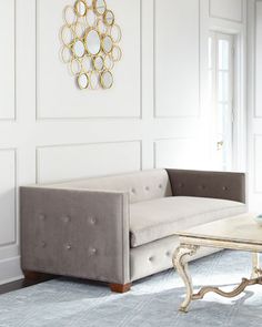 a living room with a couch and coffee table in front of a wall mounted mirror