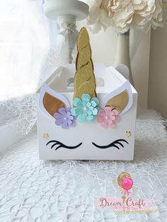 a white box with a unicorn's face on it and flowers in the front