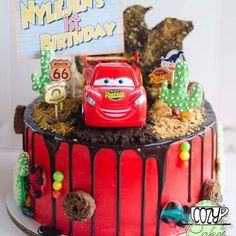 the birthday cake is decorated with cars and cactus