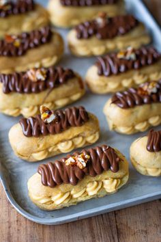 cookies with chocolate frosting and nuts are on a baking sheet, ready to be eaten