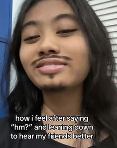 a woman with long hair and a moustache on her face is looking at the camera