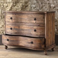 an old wooden chest of drawers in front of a wall