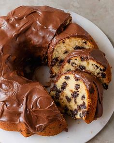 a chocolate marbled bundt cake on a white plate with one slice cut out