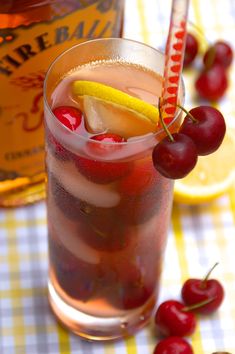 there is a drink with cherries and lemon wedges