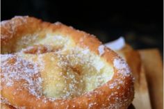 three donuts stacked on top of each other with powdered sugar and icing