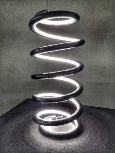 an abstract sculpture made out of black and white material with light coming from the top