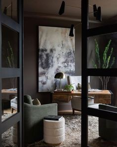 a living room filled with furniture and a painting hanging on the wall above it's doorway