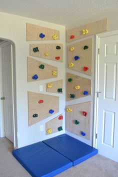 a room with several pegboards on the wall and two blue mats in front of them