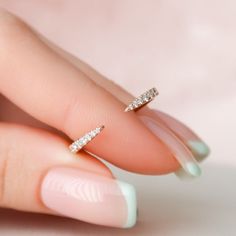 a woman's hand with a diamond ring on her finger and the tip of her fingers