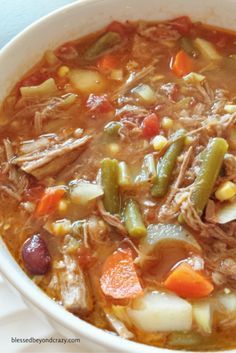 a close up of a bowl of soup with meat and veggies in it