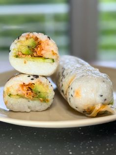 three sushi rolls sitting on top of a white plate