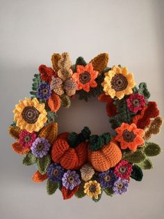 a crocheted fall wreath with pumpkins and sunflowers in the center