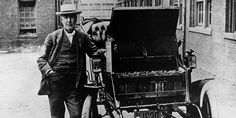 an old black and white photo of a man standing next to a horse drawn carriage