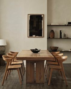 a dining room table with six chairs and a painting on the wall behind it,