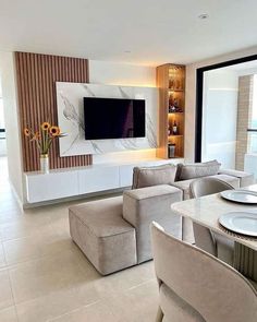 a living room filled with furniture and a flat screen tv mounted to the side of a wall