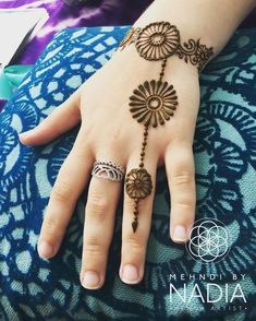 a woman's hand with henna tattoos on it