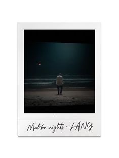 a man standing on top of a beach next to the ocean under a full moon