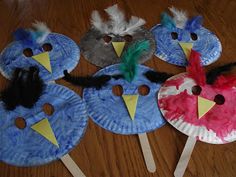 four paper plates with birds on them sitting on a wooden floor next to each other