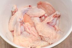 raw chicken in a white bowl on a wooden table