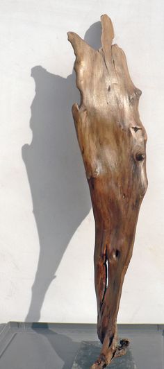 a piece of wood sitting on top of a black table next to a white wall