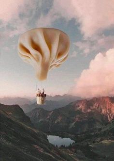 an image of a person in a hot air balloon flying over the mountain range and lake