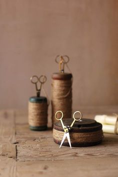 scissors and spools of thread sit on a table next to some twine