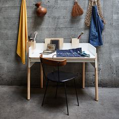 a table with some items on it next to a coat rack and potted plant